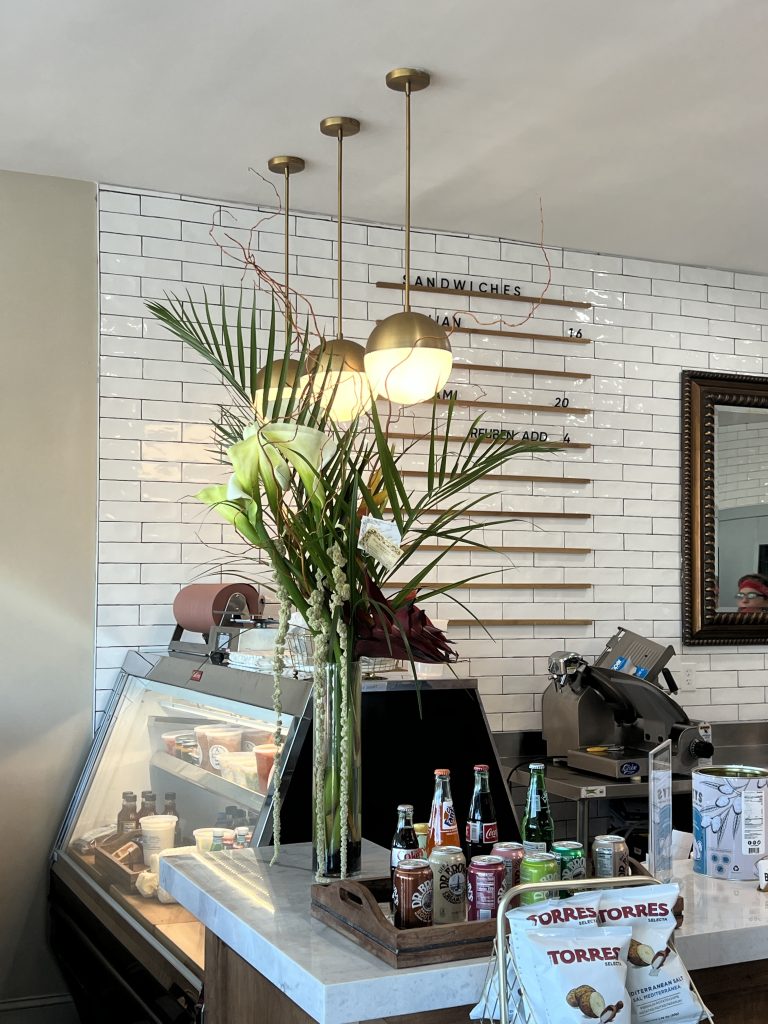 Beautiful European style floral arrangement at the counter of Beauregard's Fine Meats in Boca Raton Fl, arranged by From Roehm with Love located in Delray Beach, FL